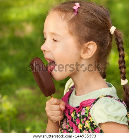 Young girls lick ice cream